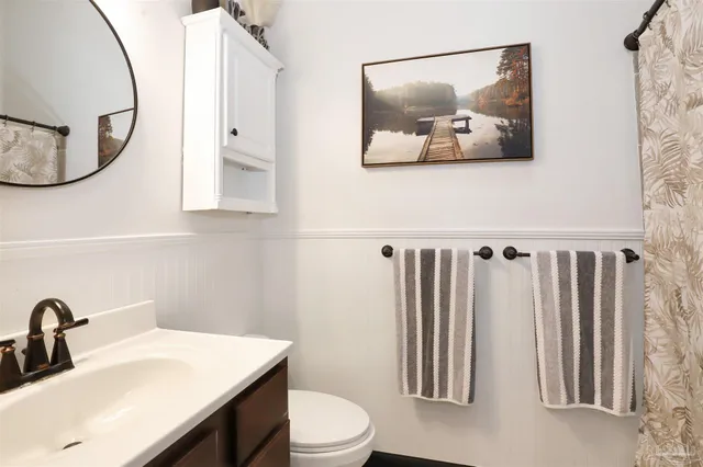 a bathroom with a toilet a sink and a mirror