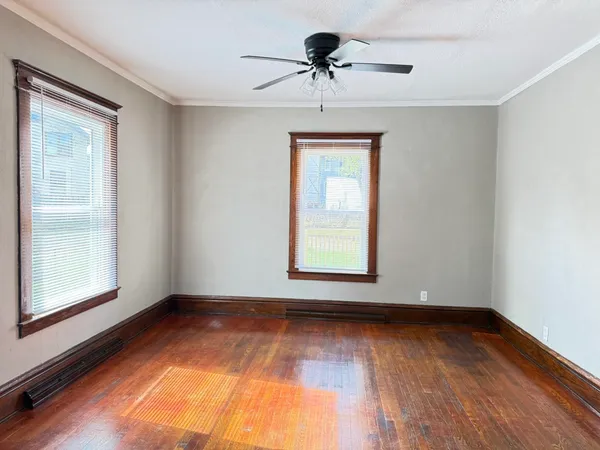 a view of room with window ceiling fan and hardwood floor