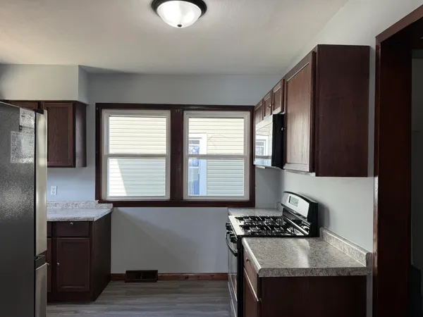a kitchen with granite countertop a sink stove and refrigerator
