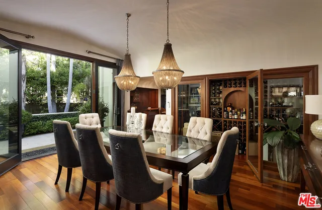 a view of a dining room with furniture a chandelier and wooden floor