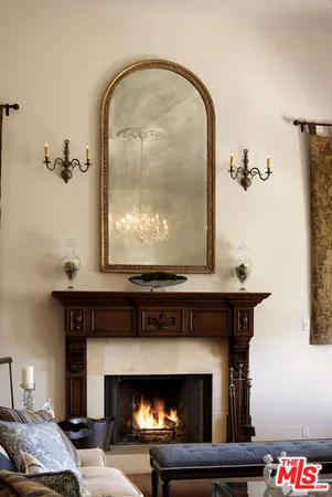a living room with furniture a fireplace and a chandelier