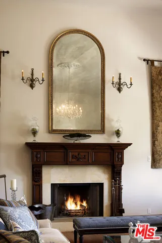 a living room with furniture a fireplace and a chandelier