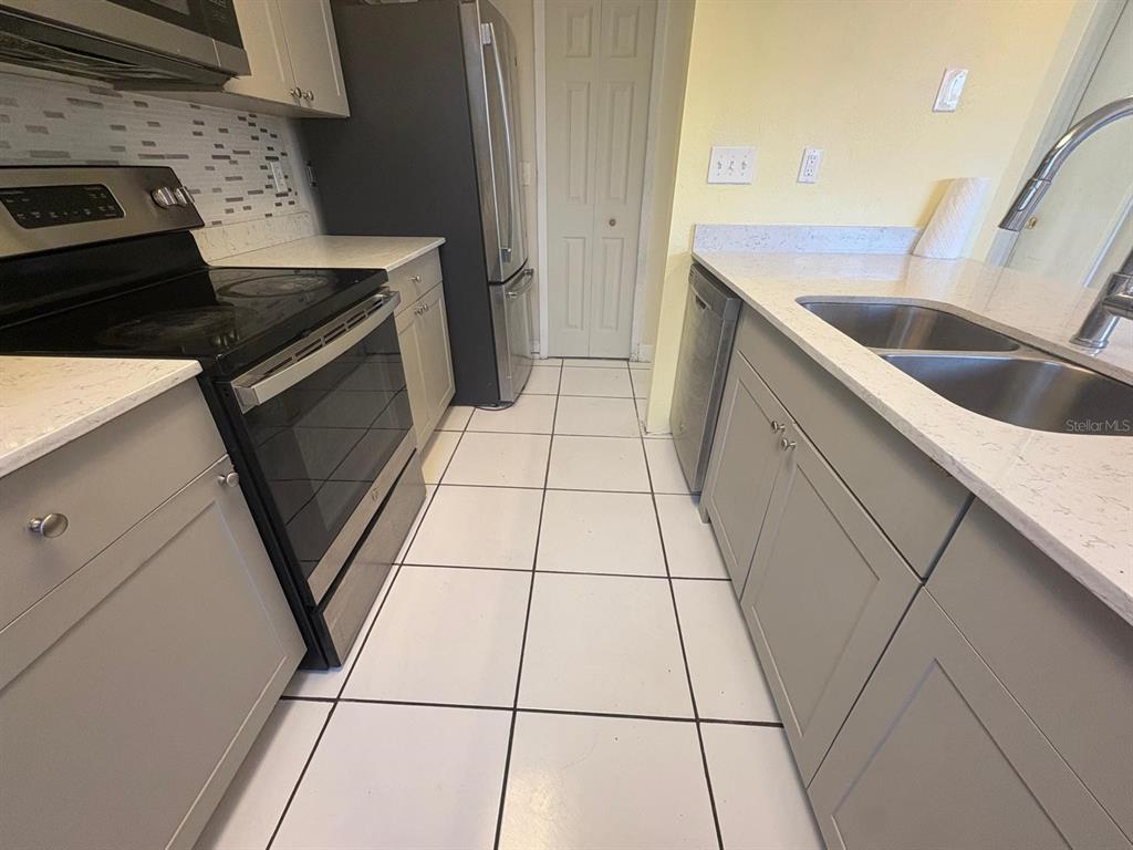 4033 Henley Road, Unit 1707 Orlando, FL 32839 - Photo 48 of 66 a kitchen with a sink and cabinets
