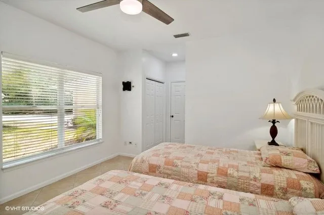 a bedroom with a large bed and a chandelier fan