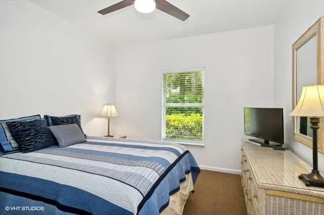a bedroom with bed tv and window