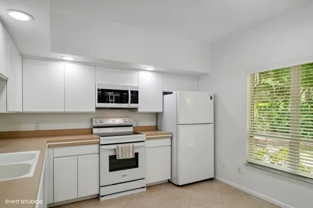a kitchen with stainless steel appliances white cabinets and a refrigerator