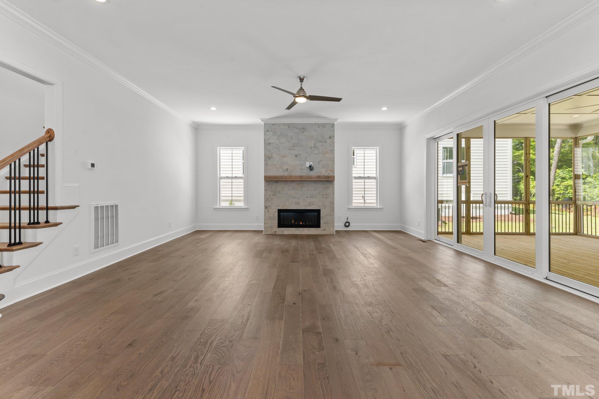 9312 Field Maple Court Raleigh, NC 27613 - Photo 7 of 49 wooden floor fireplace and windows in an empty room
