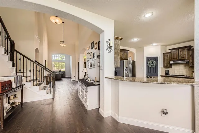 a kitchen with stainless steel appliances a refrigerator and a wooden floor