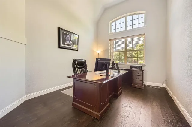 a view of a workspace with furniture and a window