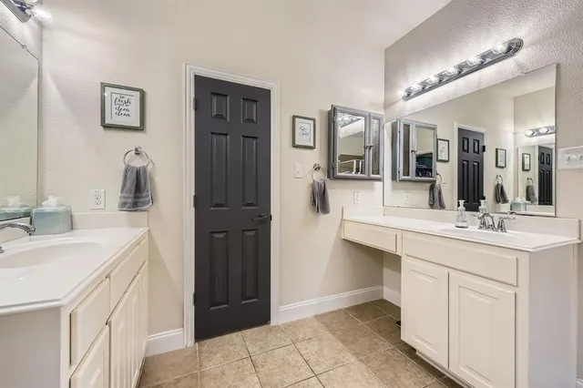 a bathroom with a double vanity sink mirror and bathtub