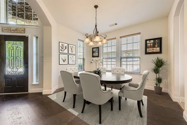 a dining room with furniture a chandelier and wooden floor