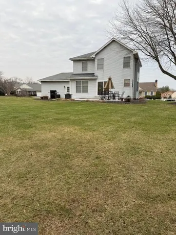 a front view of house with yard and trees in the background