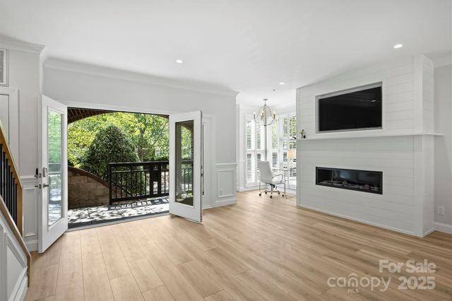 a view of an empty room with wooden floor and a fireplace