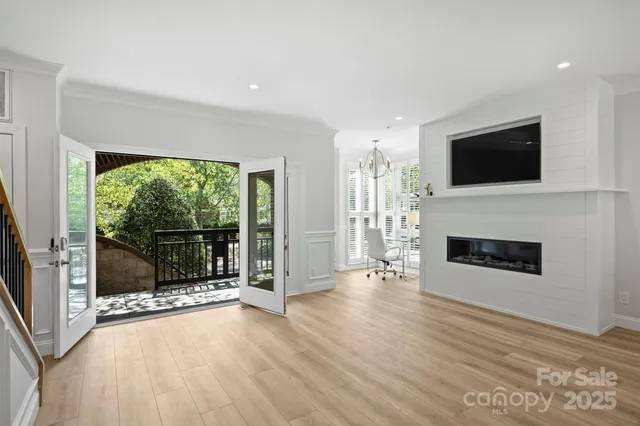 a view of an empty room with wooden floor and a fireplace