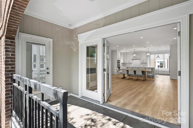 a view of a living room and a dining room with wooden floor