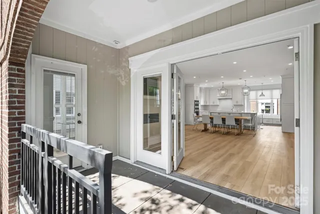 a view of a living room and a dining room with wooden floor