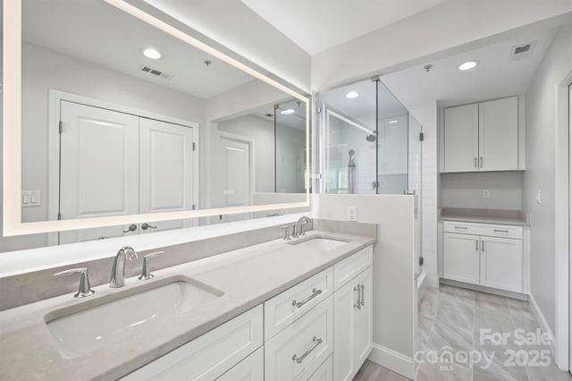a bathroom with a sink double vanity granite and a mirror