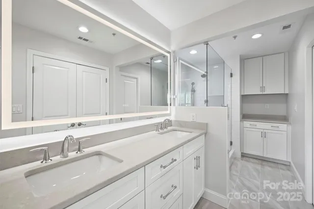 a bathroom with a sink double vanity granite and a mirror