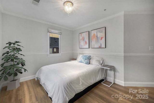a bedroom with a large bed and a chandelier