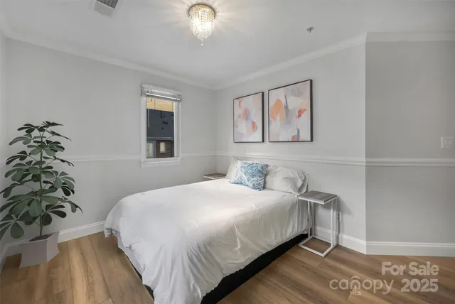 a bedroom with a large bed and a chandelier