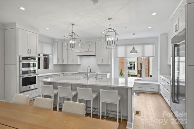 a kitchen with stainless steel appliances kitchen island granite countertop a table and chairs in it