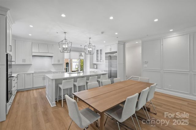 a kitchen with kitchen island a table and chairs in it