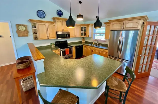 a kitchen with stainless steel appliances granite countertop a stove a sink and a microwave