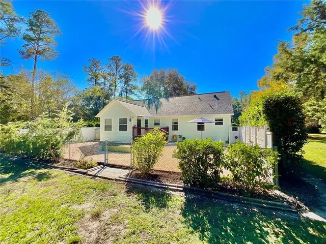 a view of a house with a yard and sitting area