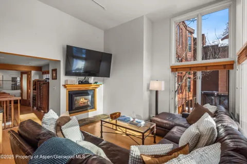 a living room with furniture a flat screen tv and a fireplace