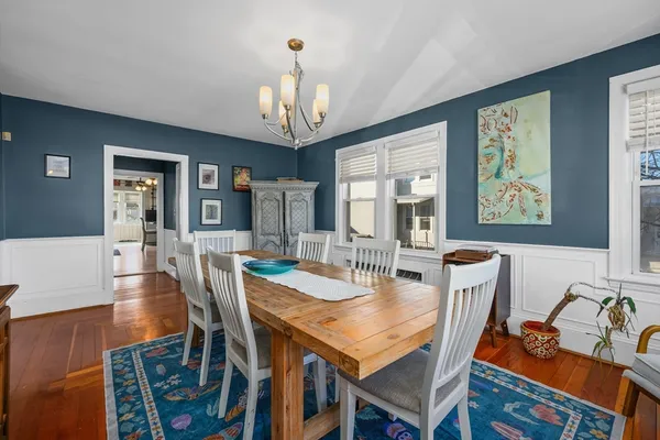 a view of a dining room with furniture a chandelier and wooden floor