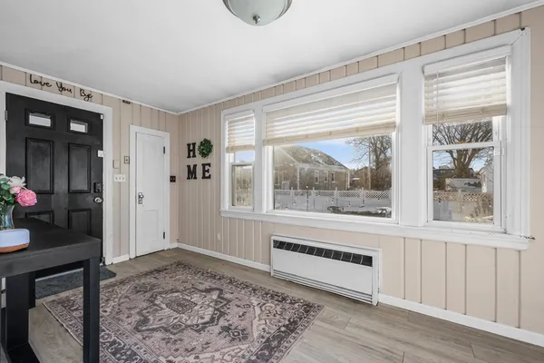 a view of a livingroom with wooden floor and a rug