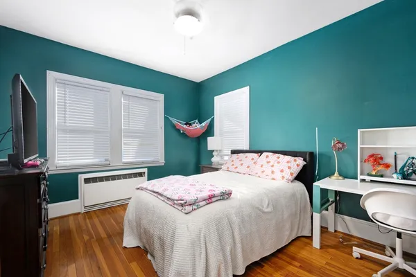 a bedroom with a bed and wooden floor