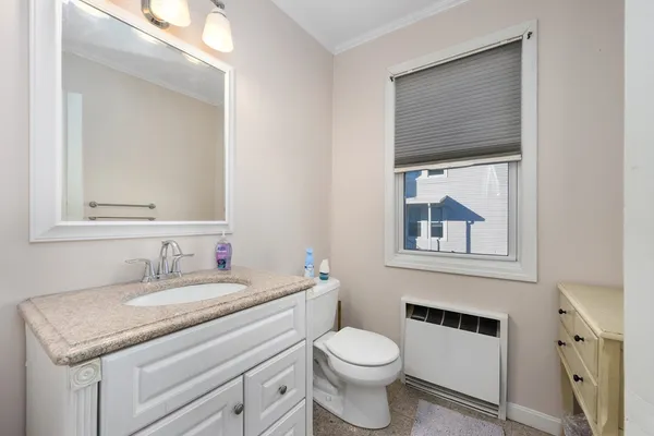 a bathroom with a granite countertop toilet sink and mirror