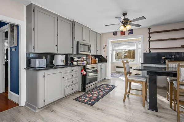 a kitchen with stainless steel appliances kitchen island granite countertop a stove refrigerator and cabinets