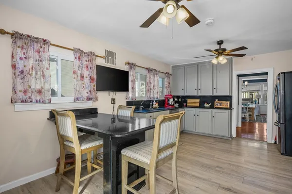 a kitchen with a table chairs refrigerator and cabinets