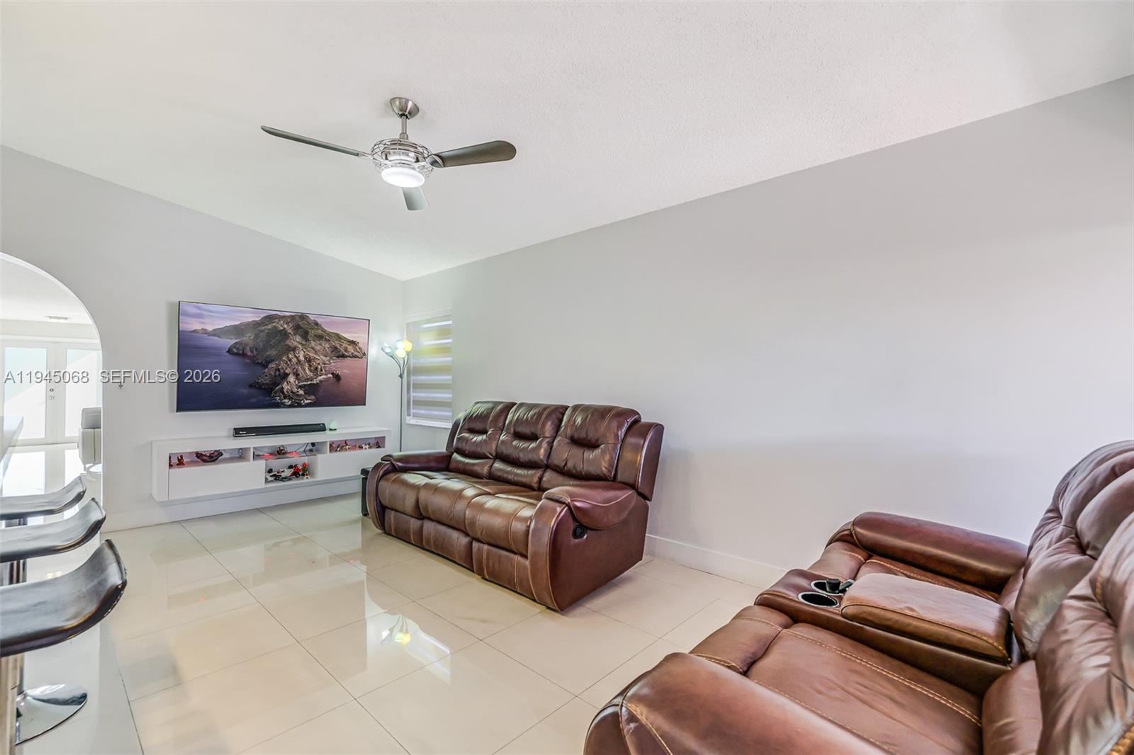 9526 Southwest 155th Avenue Miami, FL 33196 - Photo 12 of 53 a living room with furniture and a flat screen tv
