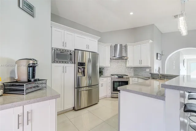a kitchen with stainless steel appliances granite countertop a refrigerator stove and sink