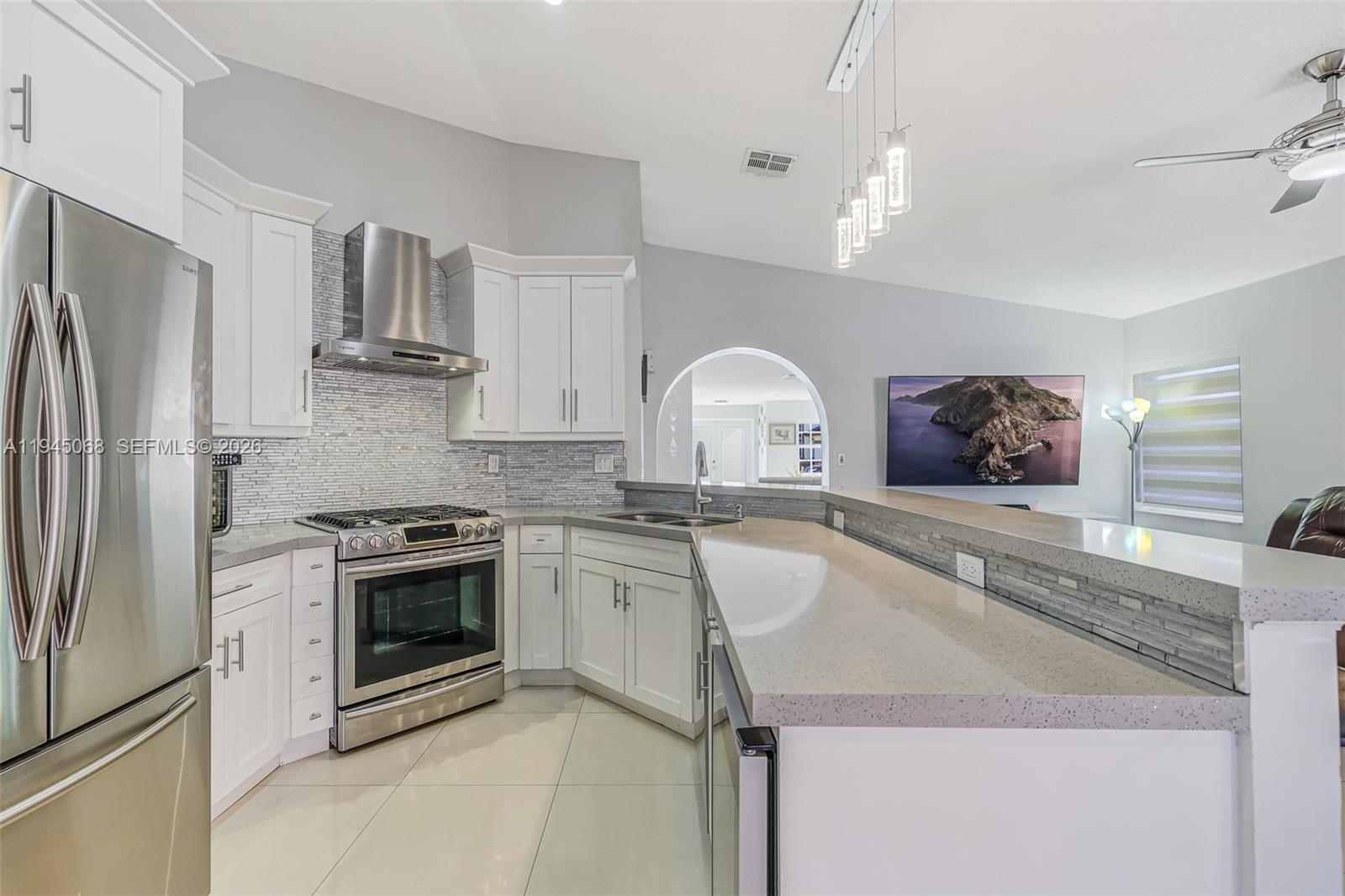 9526 Southwest 155th Avenue Miami, FL 33196 - Photo 19 of 53 a kitchen with stainless steel appliances granite countertop a sink stove and refrigerator