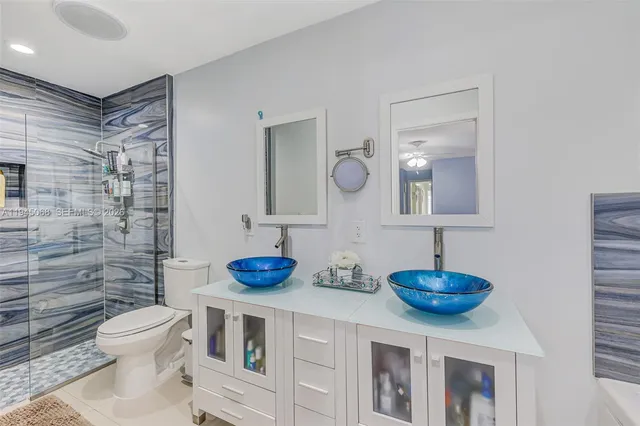 a bathroom with a sink a toilet and a mirror