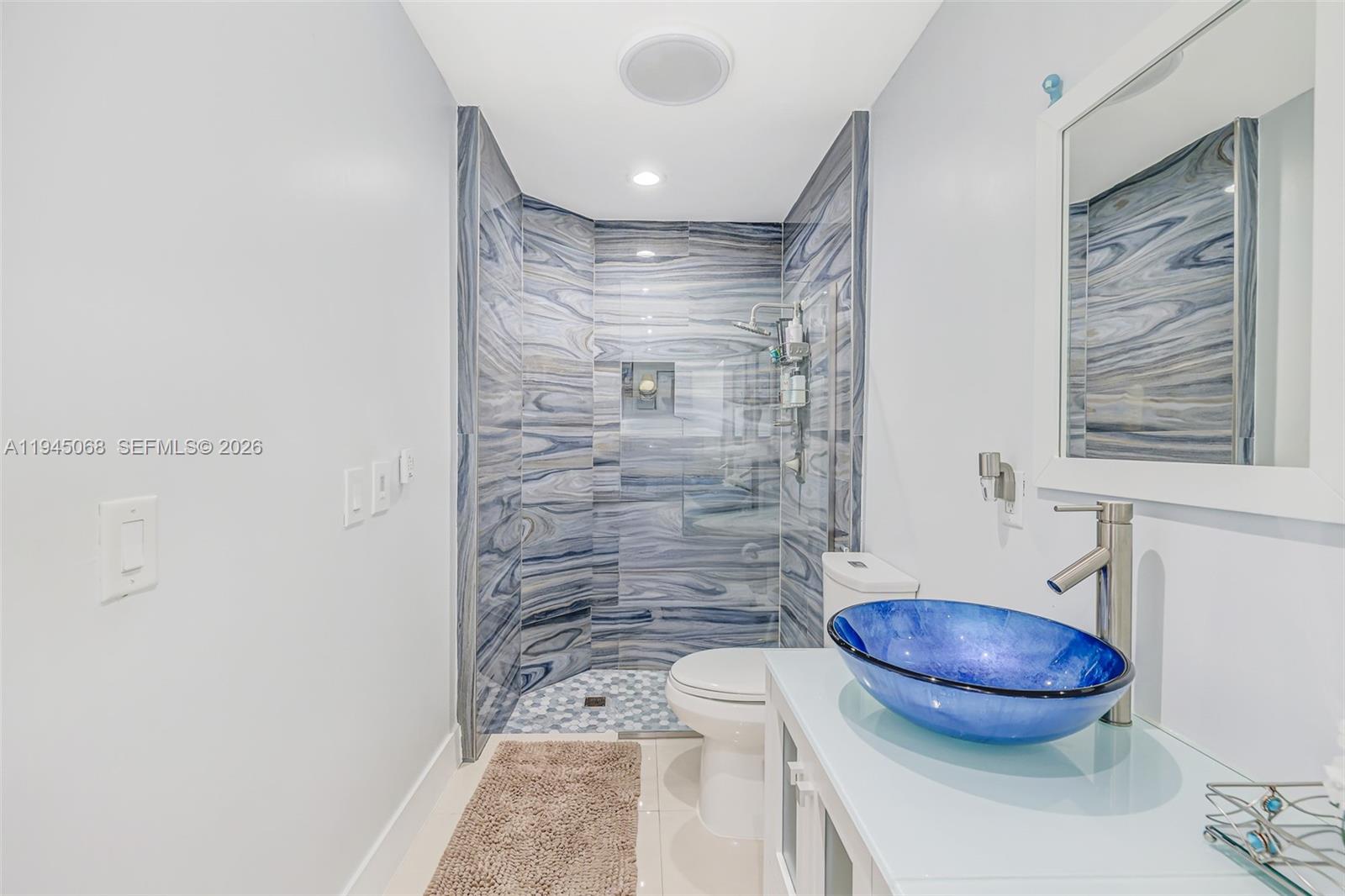 9526 Southwest 155th Avenue Miami, FL 33196 - Photo 38 of 53 a bathroom with a granite countertop sink a toilet and a mirror