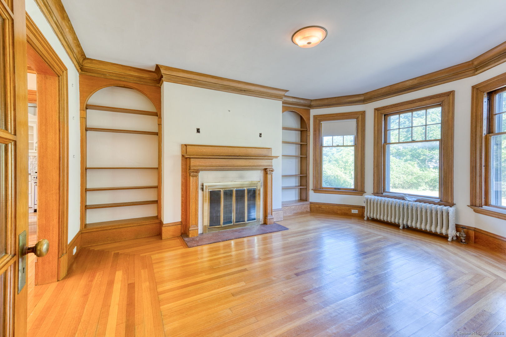 202 South Main Street Manchester, CT 06040 - Photo 12 of 40 an empty room with wooden floor fireplace and windows