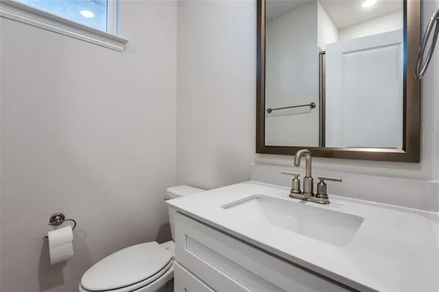 a bathroom with a toilet a sink and mirror