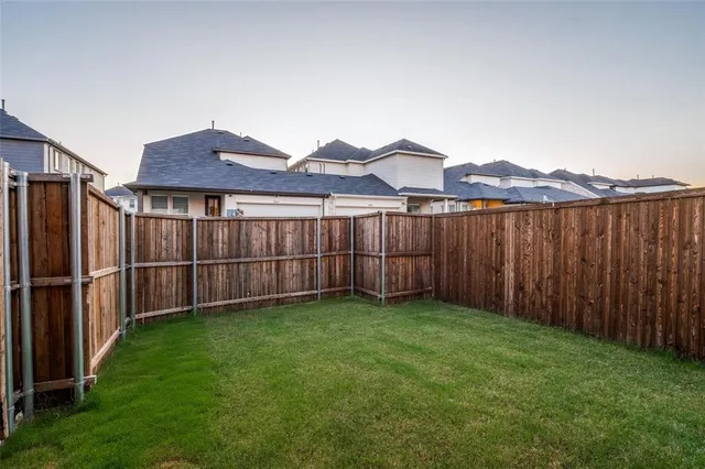 a view of a backyard with wooden fence