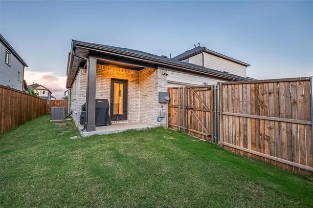 a view of backyard with barbeque grill and wooden fence