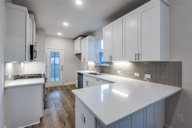 a kitchen with granite countertop a sink a stove and refrigerator