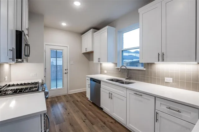 a kitchen with stainless steel appliances granite countertop a sink stove and refrigerator