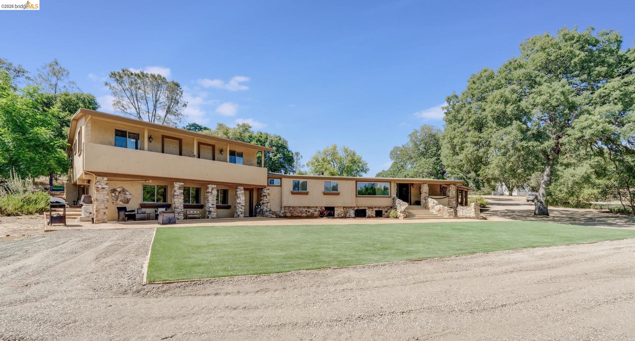 a view of a house with a big yard and large trees