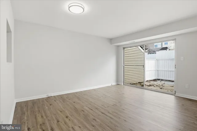 an empty room with wooden floor and white walls