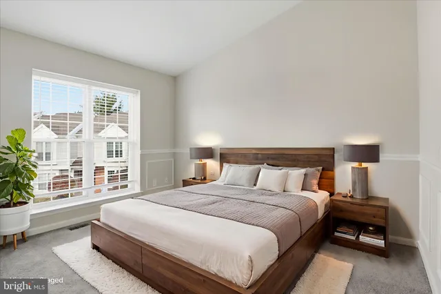 a bedroom with a bed and a large window