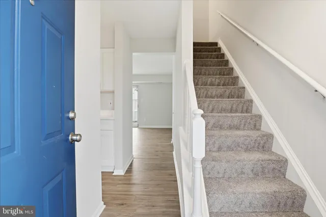 a view of a hallway with wooden floor and entryway